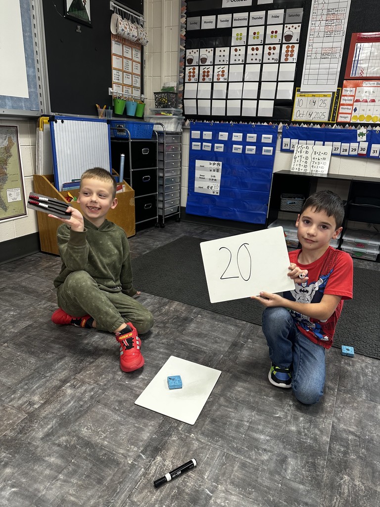 Two boys holding up their math activity.