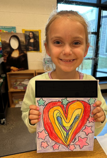 Smiling student with hear art work.