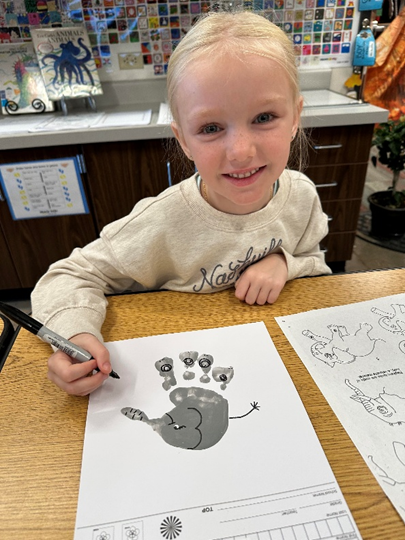 Smiling student with hand art work.