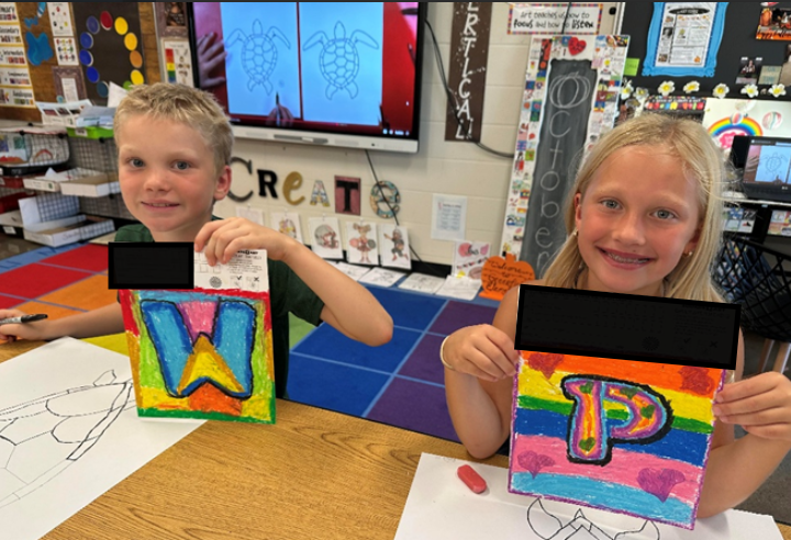 Two students with letter art work.