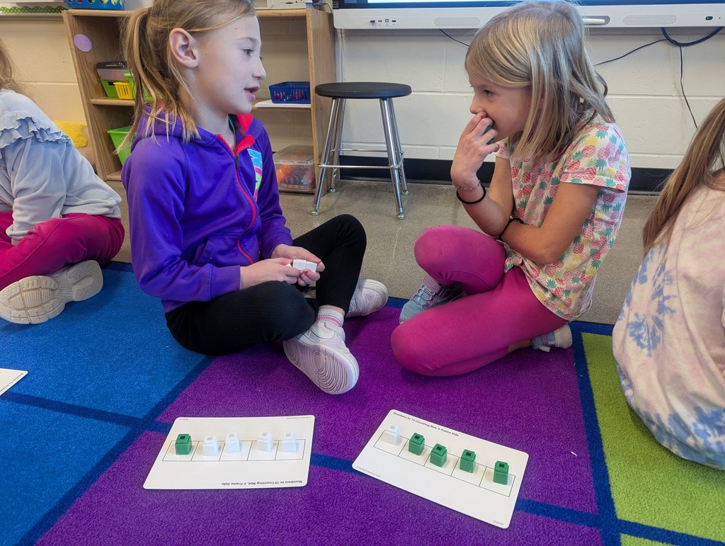 Two girls talking on the carpet