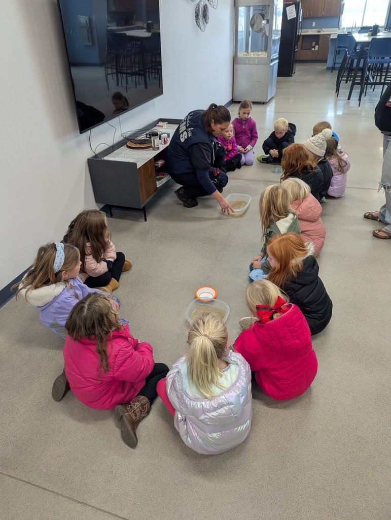 Students in a circle listening to EMS staff.