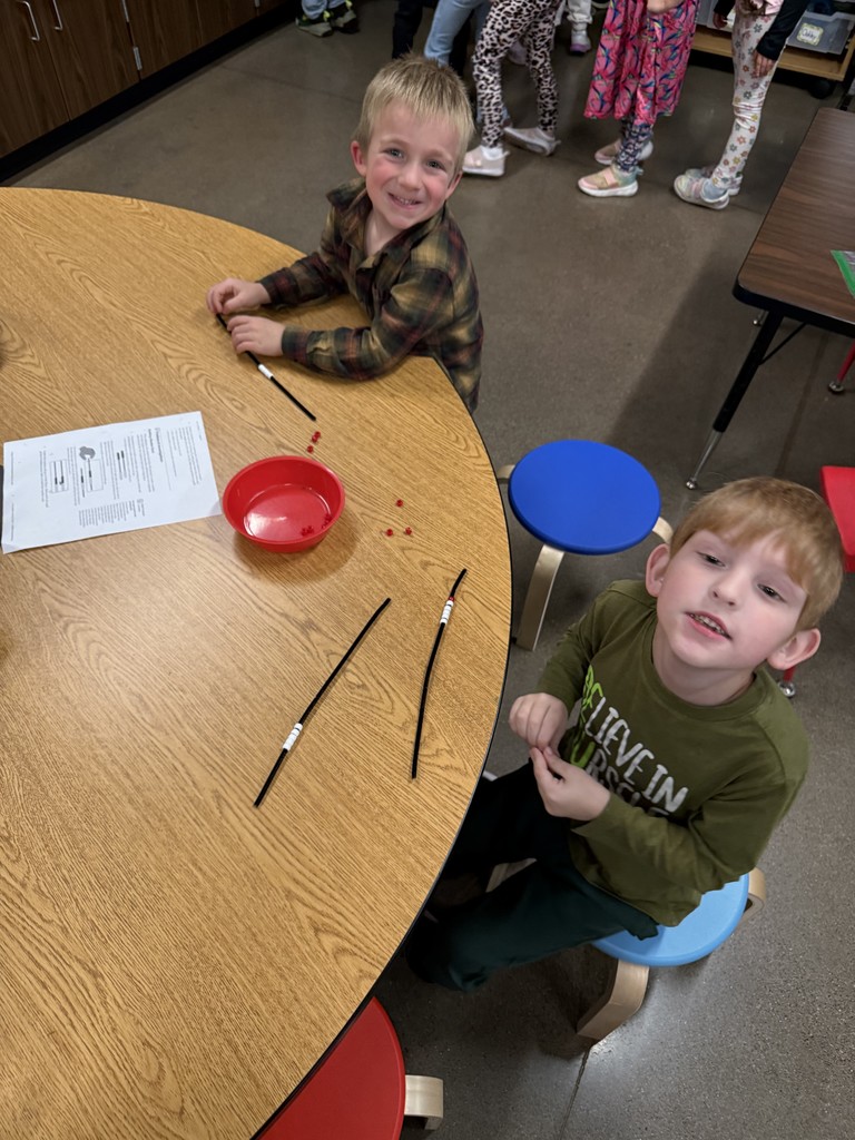 Two students at a table with number racks.