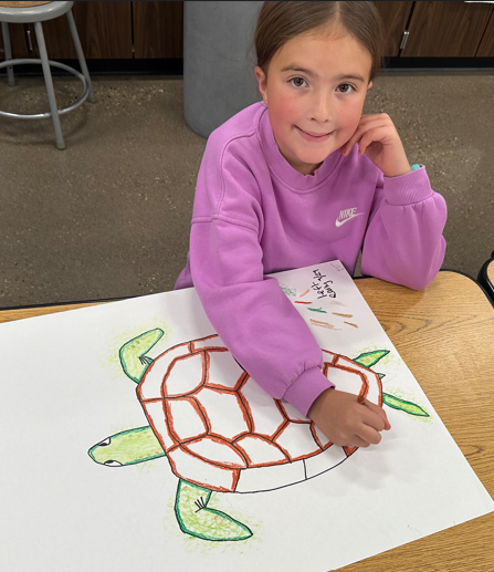 A student smiling and coloring.