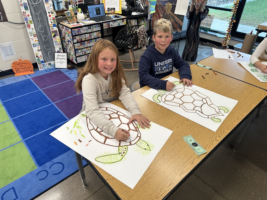 A boy and girl coloring their sea turtle.