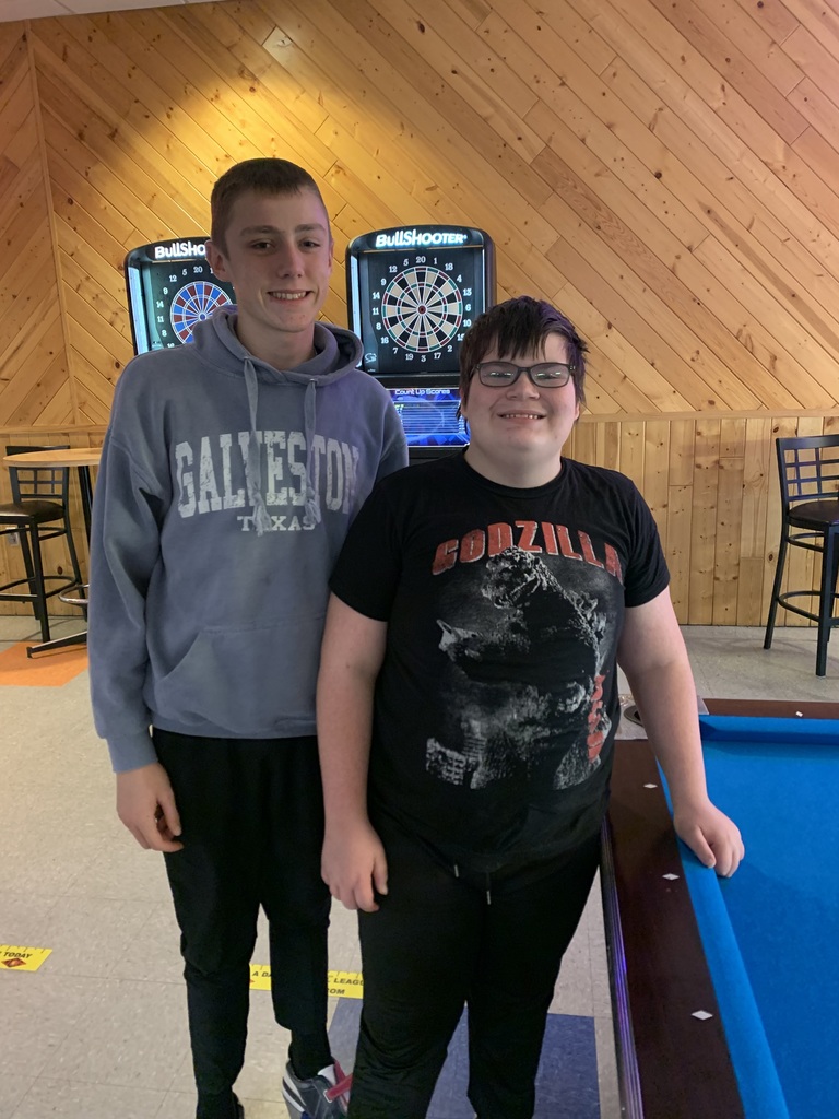 Two students standing by a pool table.