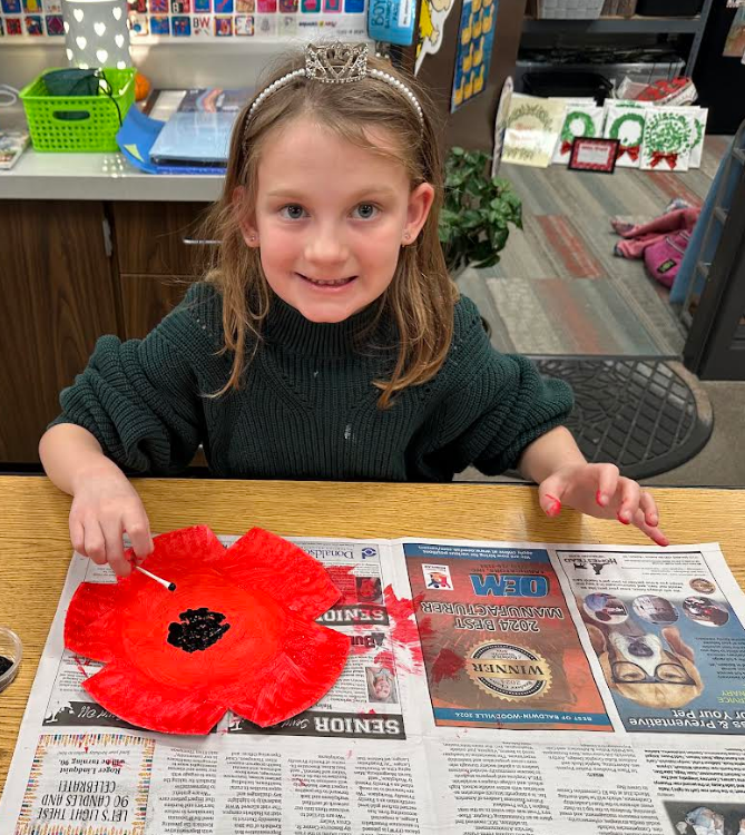 Smiling student working on her poppy.