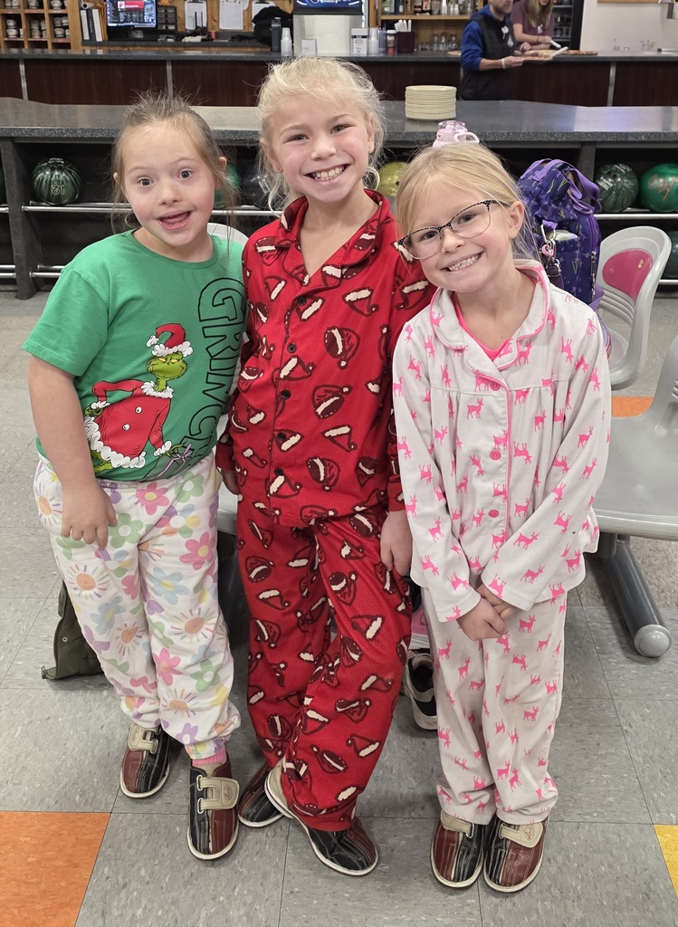 Three smiling girls in their Christmas pajamas.