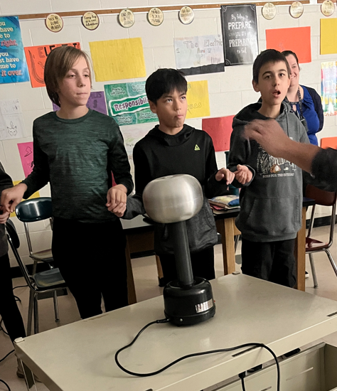 Students in a circle holding hands.