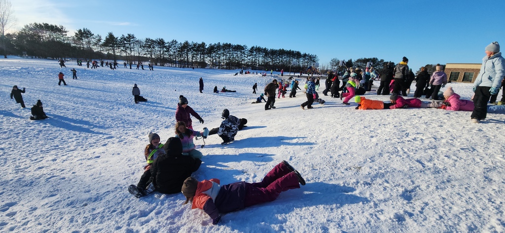A playground full of students playing in the snow.