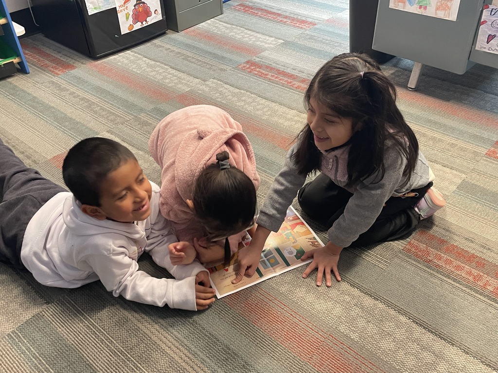 Three students on the floor reading.