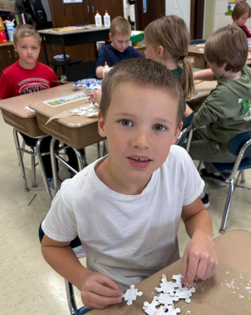 Student sitting at desk with their ornament.