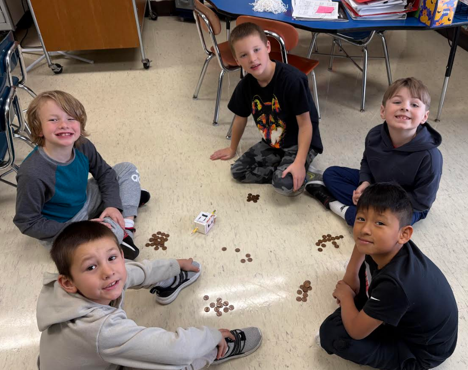 Five students smiling while playing a game.