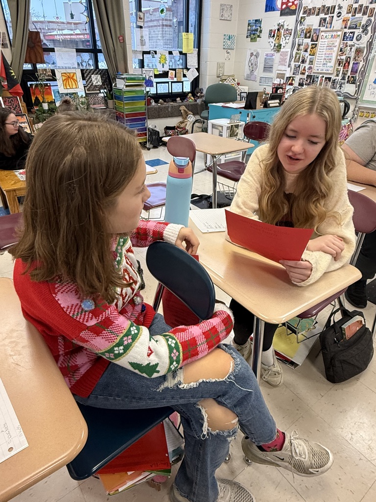 Two girls at their desk reading.