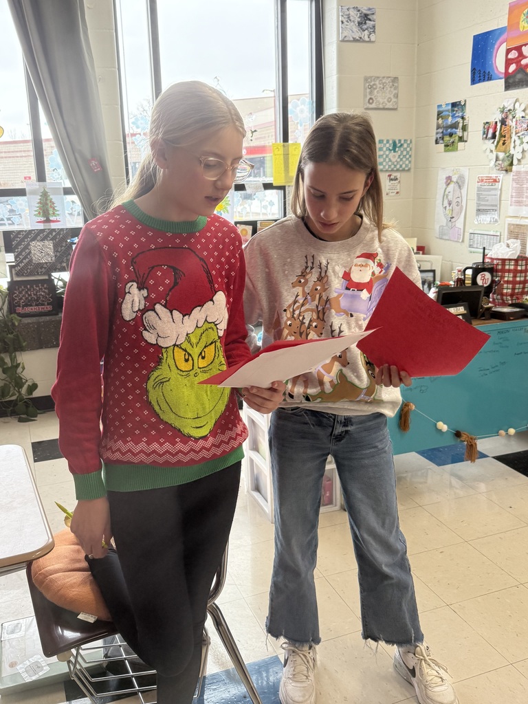 Two girls reading to eachother.