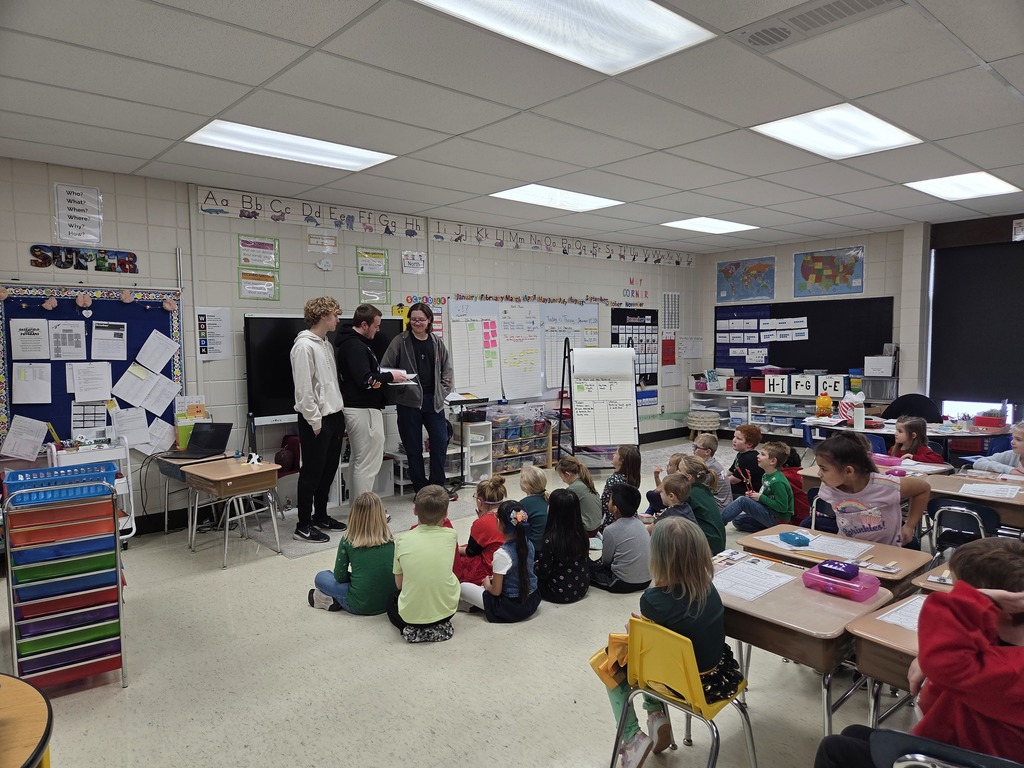 Students reading to elementary students.