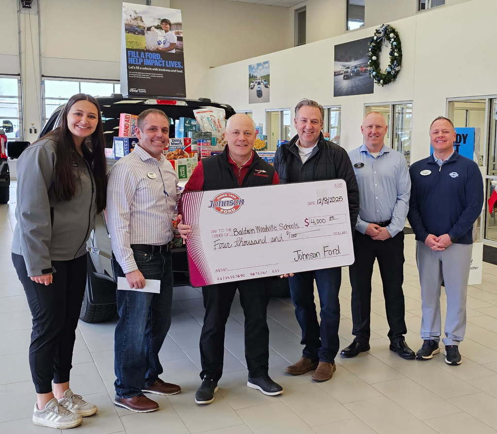 Johnson Motors staff and Chad Brakke with the large check.