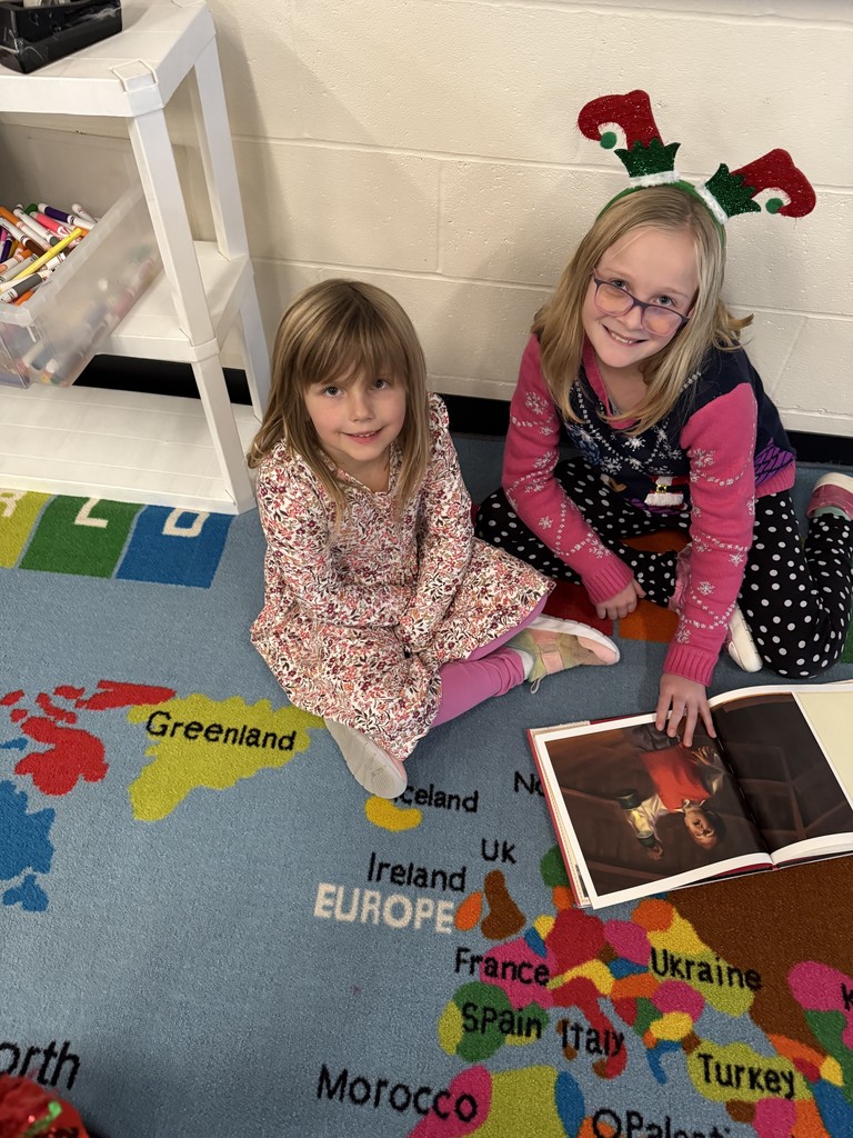 Two students reading on the floor.