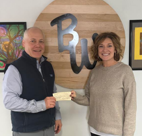 Chad Brakke and Kelsey Brewer with a check.