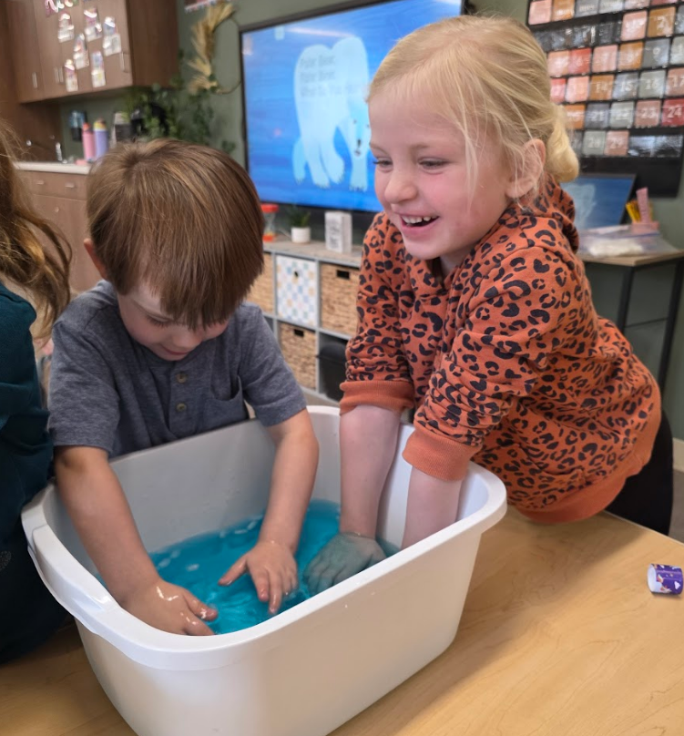 Laughing students with hands in cold water