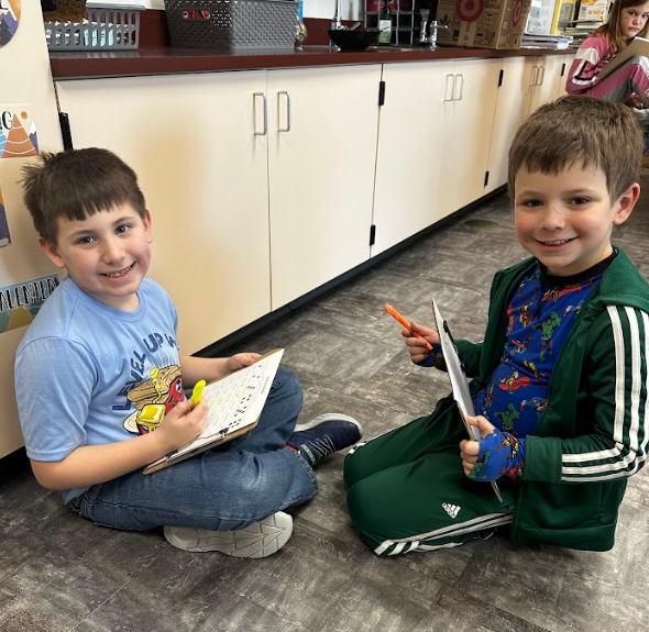 Two boys smiling with their worksheets