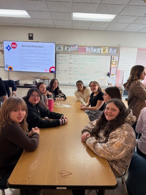 Students smiling while sitting at the table.