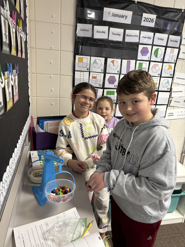 Three students measuring mass 