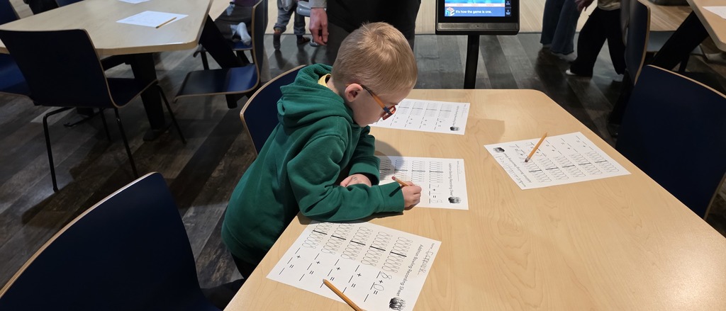 Student working on a math sheet at the bowling alley.