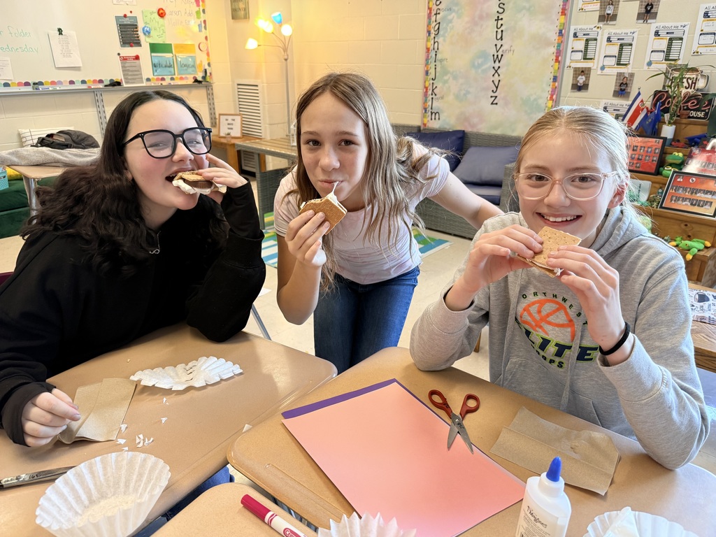 Three students enjoying their smores at their desks.