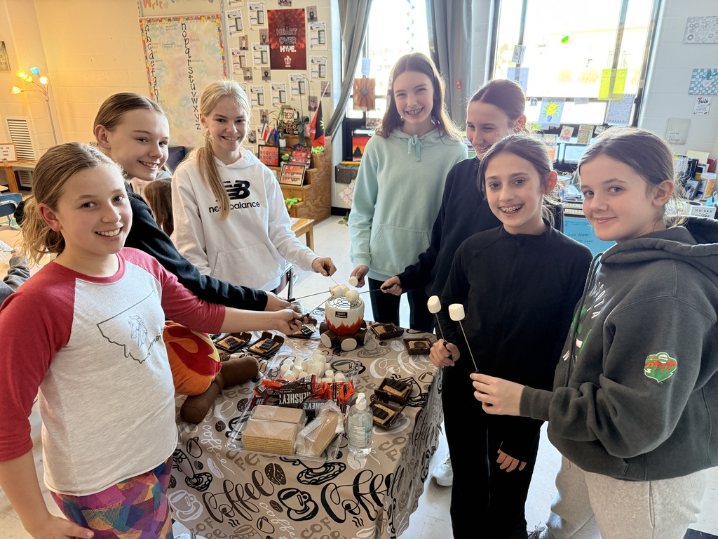 A group of girls making smores in class.