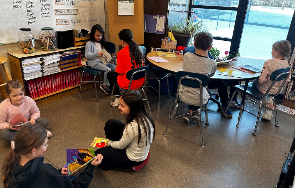 Picture of a classroom with students sitting together and reading.