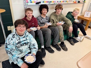 Five students smiling with bowls of ice cream.