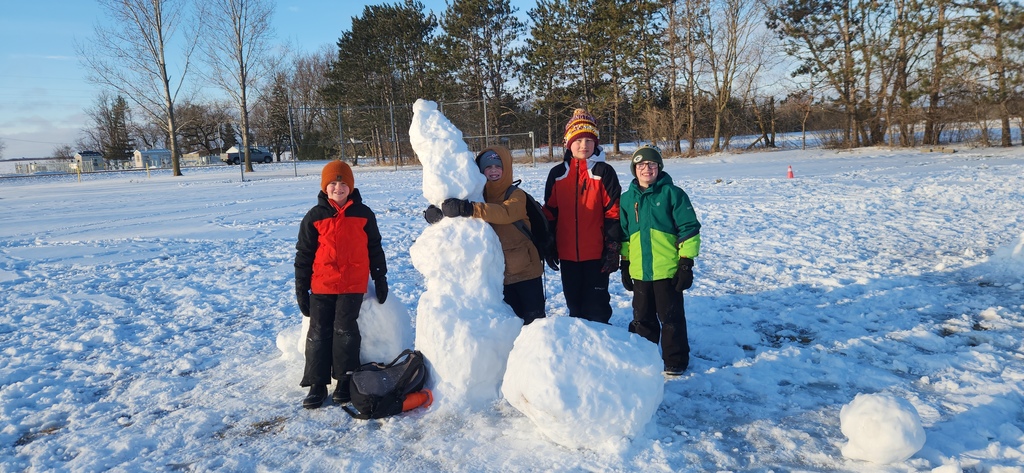 Students smiling with their snow creations.