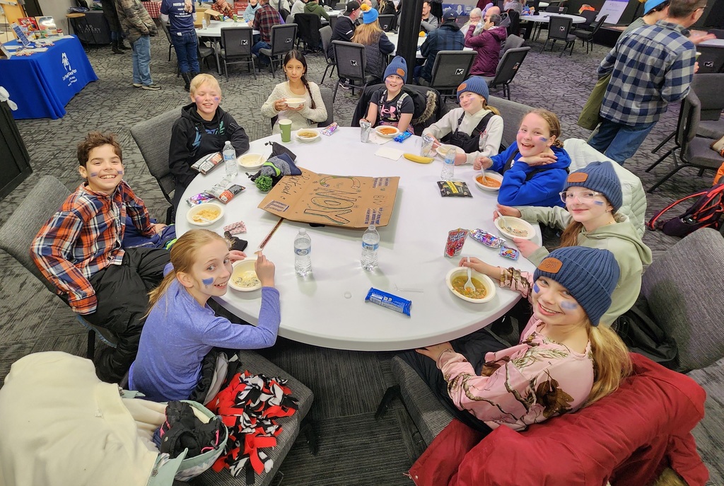 Students eating soup inside at the event.