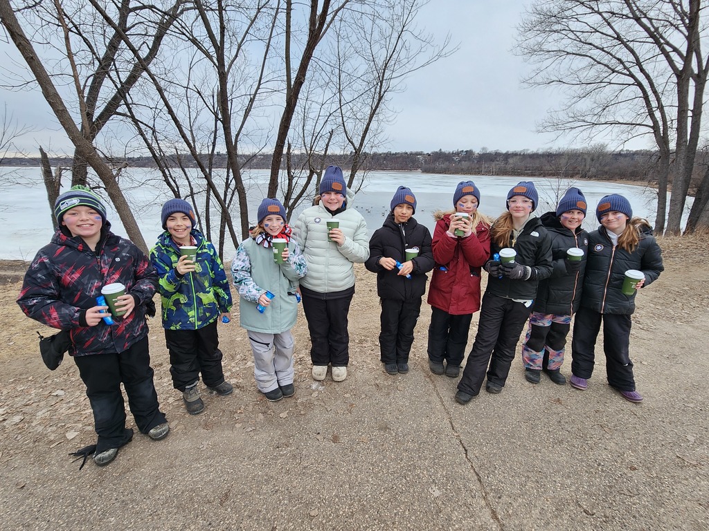 All students with their hot chocolate smiling by the river.