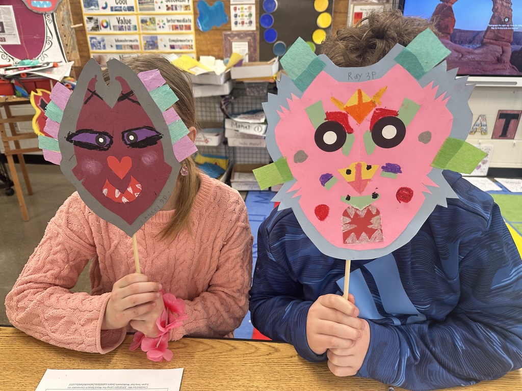 Two students holding up their masks.