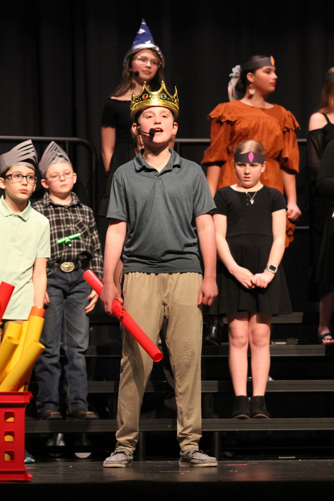A boy dressed as a king singing his solo.