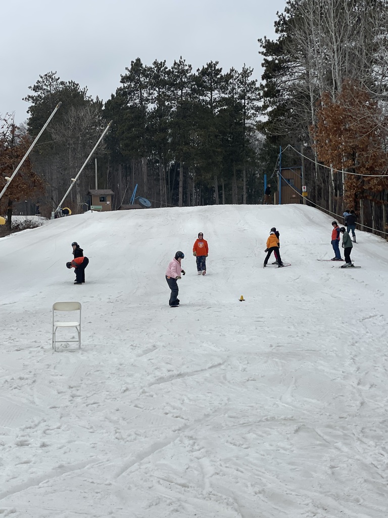 Students and instructors skiing down the hill.