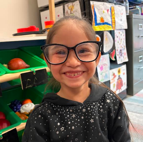 Student smiling with teacher's glasses.
