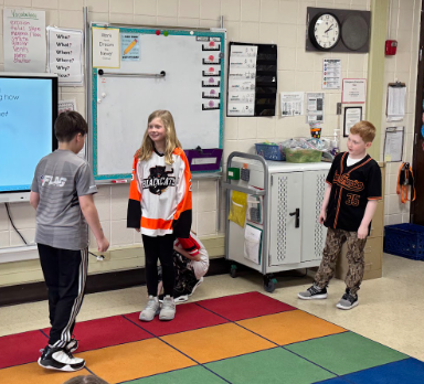 Four students acting out the book.