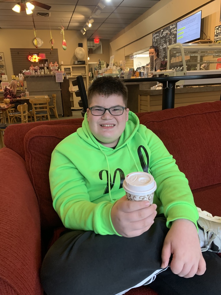 Student smiling with their hot chocolate at Baldwin Perk.