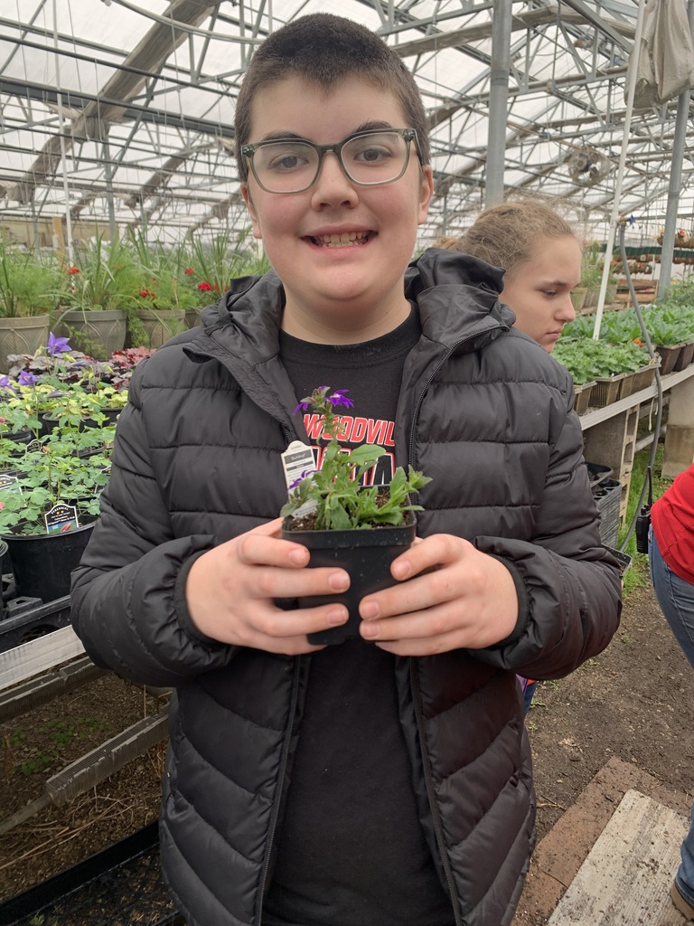 Student smiling with his flower.