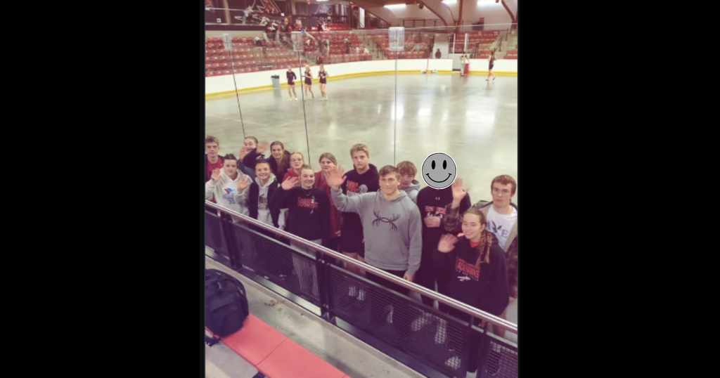 High school track athletes waving at the camera.