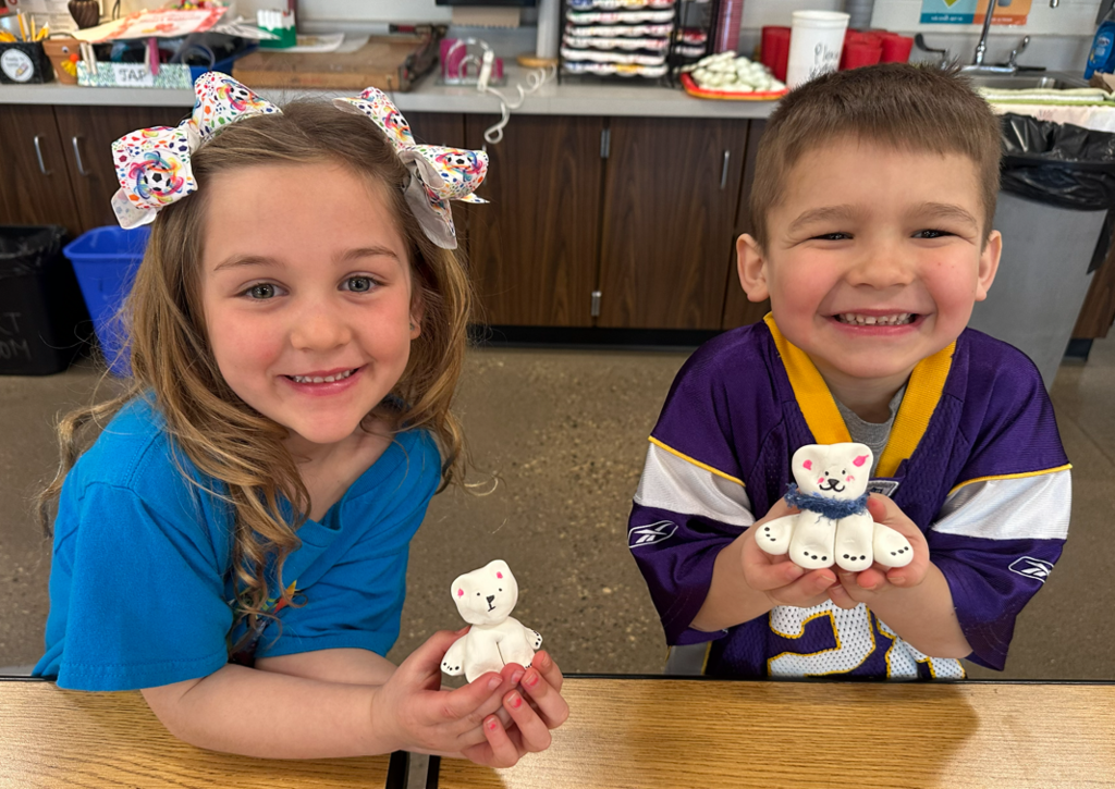 A little boy and girl smiling with their polar bears.