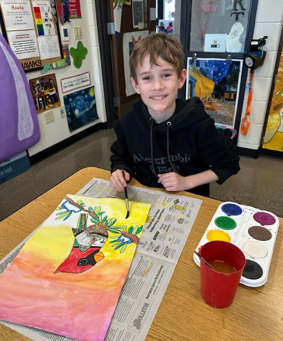 Smiling boy with his art project.