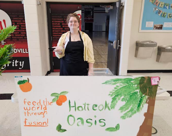 A student smiling with her "food truck"  HOTTEOK OASIS