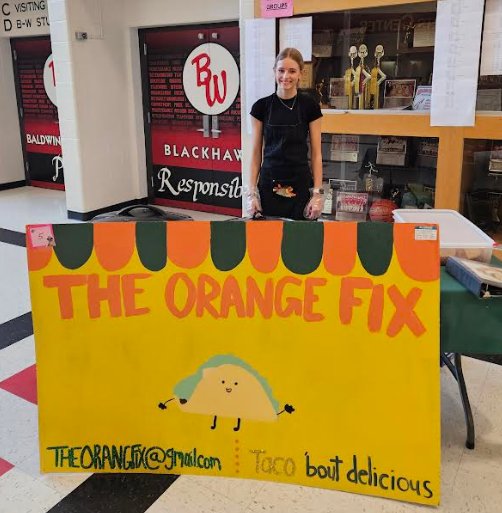 A student smiling with her "food truck" THE ORANGE FIX