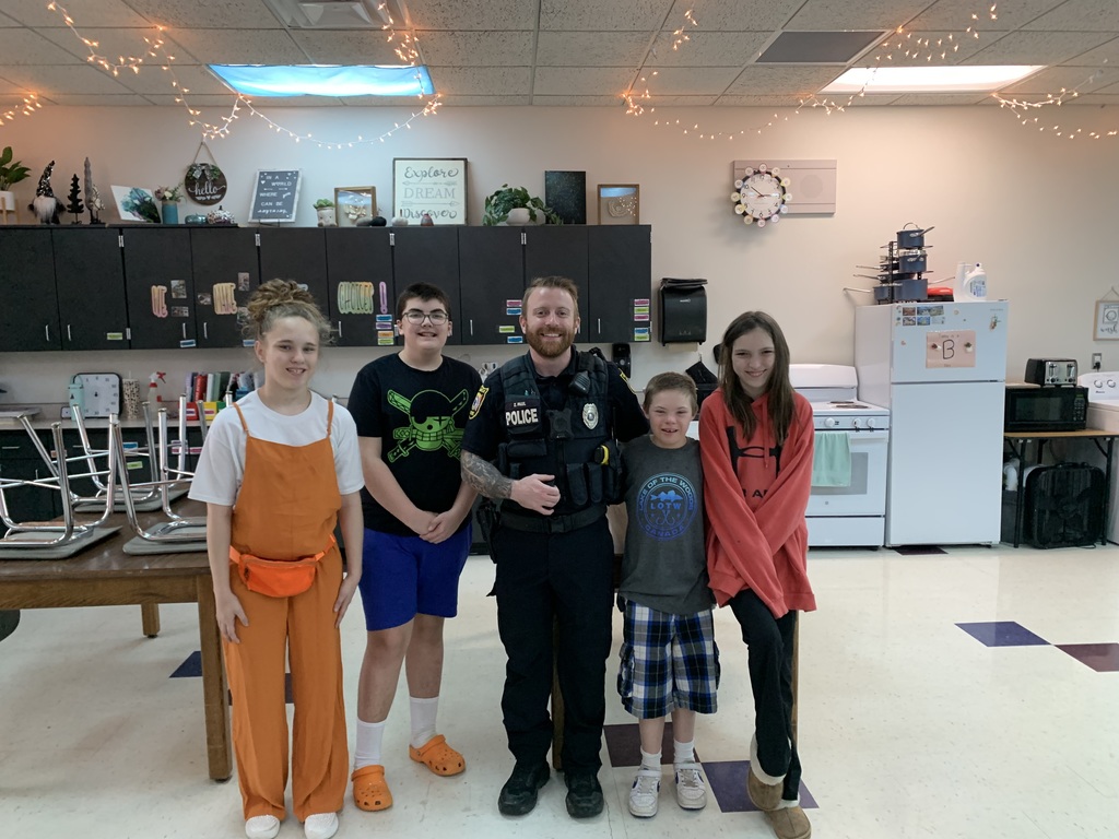 Students smiling with Officer Paul.