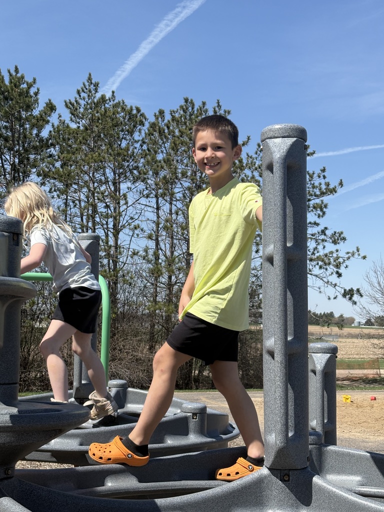 A little boy climbing and smiling.