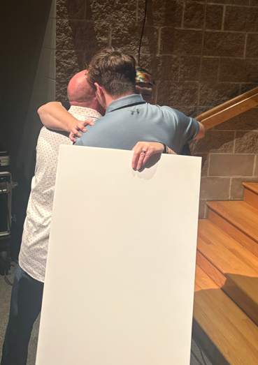 Mrs. Schmoker hugging her husband and son.